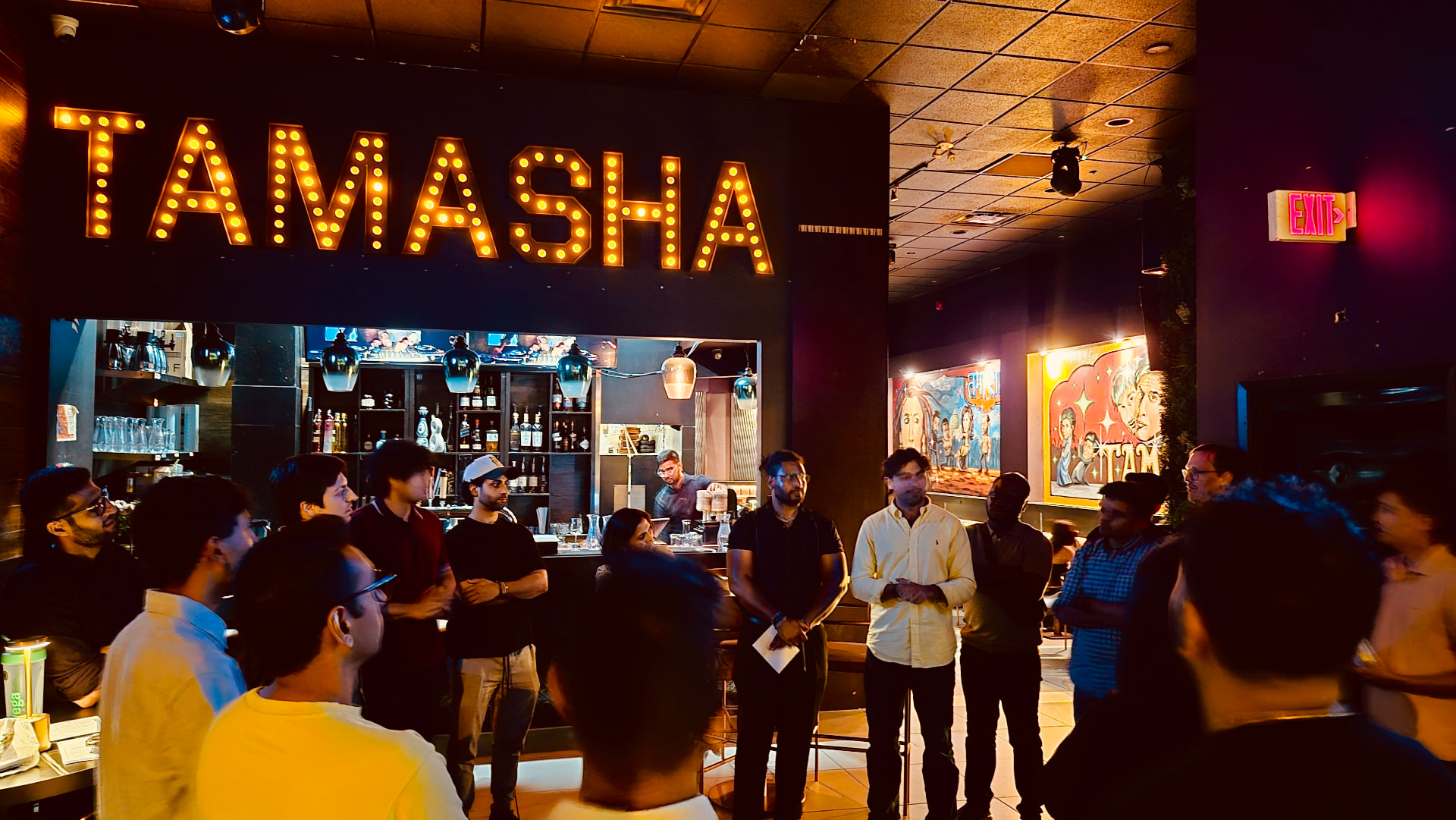 A group gathered under a lit marquee sign at a LocoBloco night