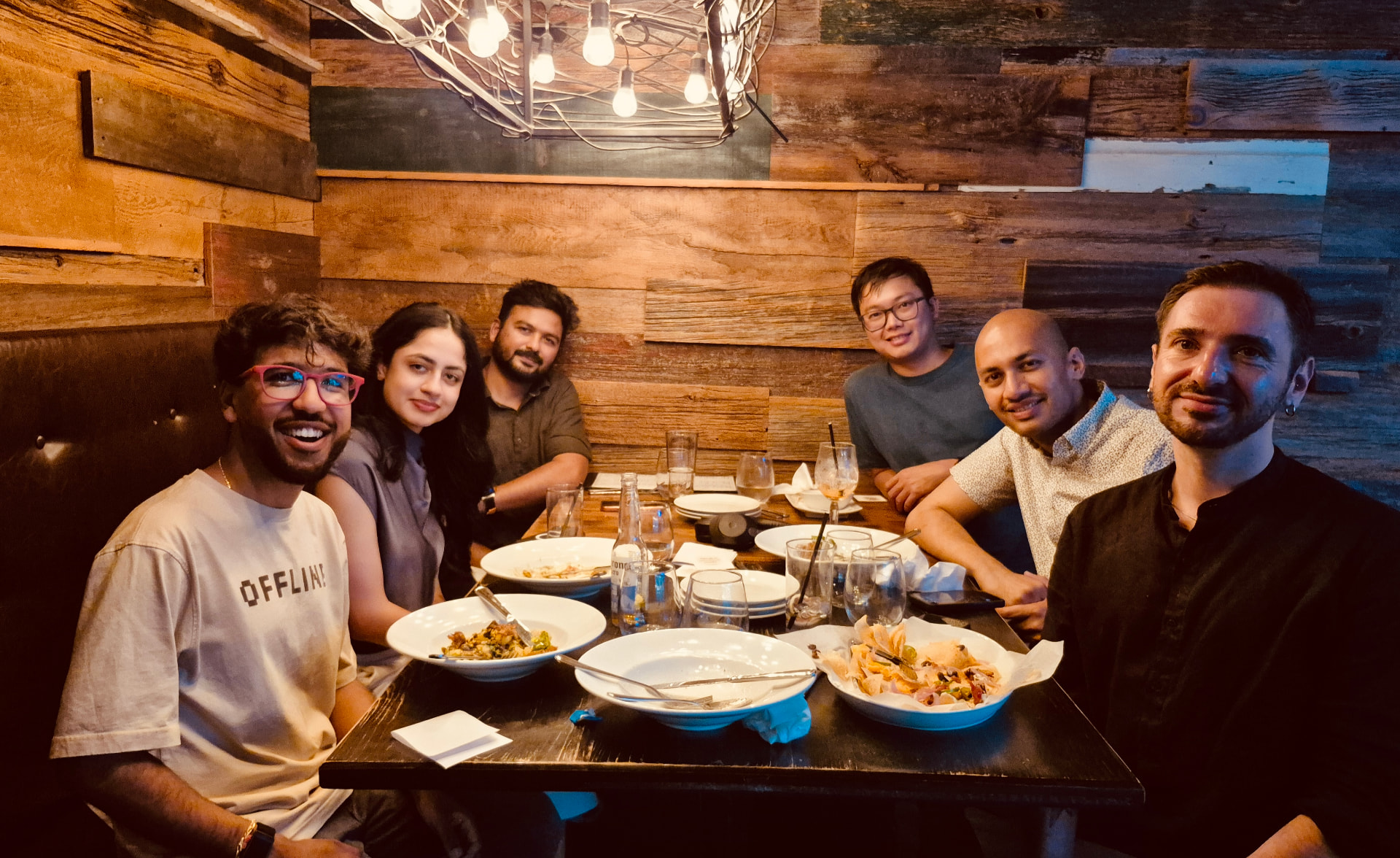 Six people posing together around a finished dinner table
